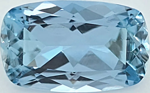 A cushion-cut light blue gemstone with a faceted, geometric pattern, shown on a plain white background.