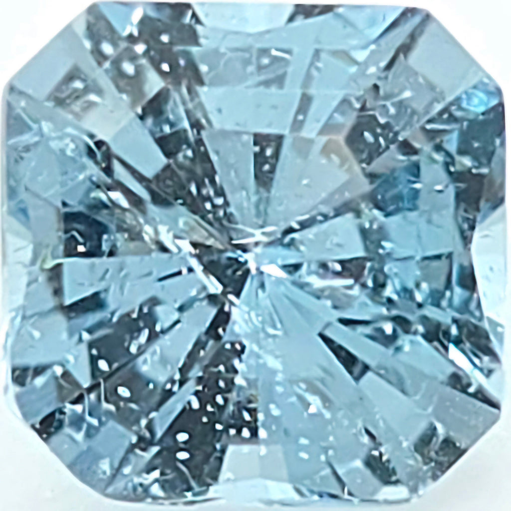A close-up of a light blue octagonal gemstone with a brilliant faceted cut, showing internal reflections and tiny inclusions.