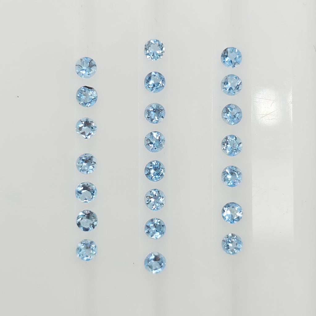 22 light blue round faceted blue gemstones arranged in three vertical columns on a plain white background.