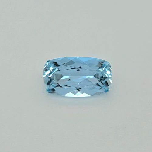 A light blue cushion-cut faceted gemstone centered on a plain light gray background.