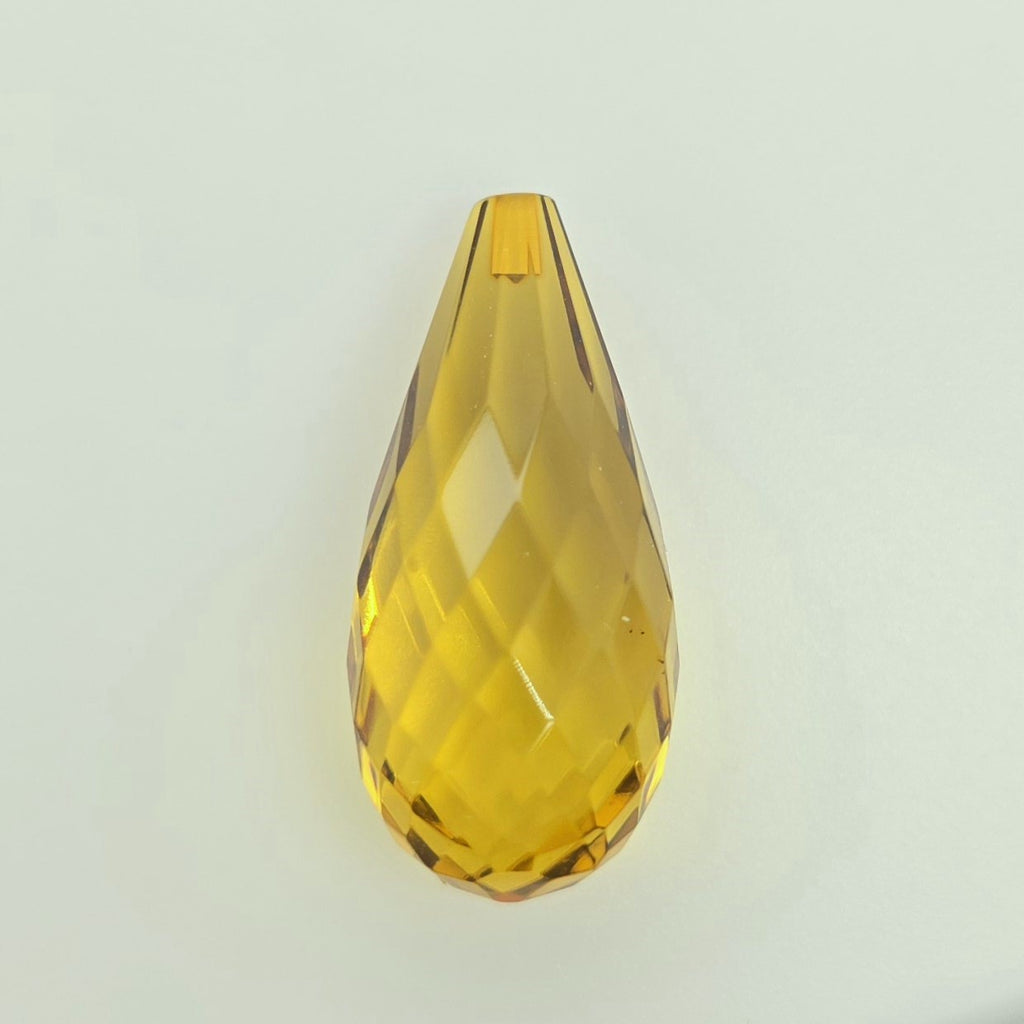 A faceted teardrop-shaped translucent greenish yellow briolette, shown on a plain light gray background.