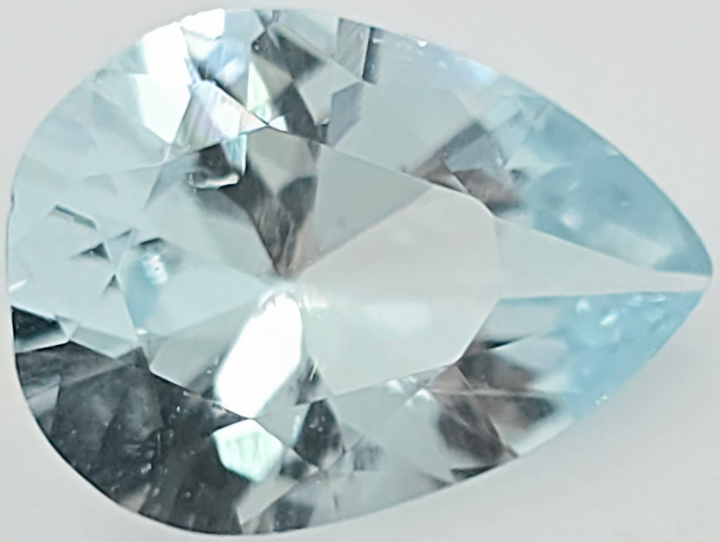 A faceted pear-shaped light blue gemstone, shown in close-up on a plain light background.