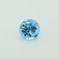 A faceted round blue gemstone on a plain light background