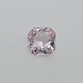A single loose squaare radiant cut pink gemstone, centered on a plain light gray background.