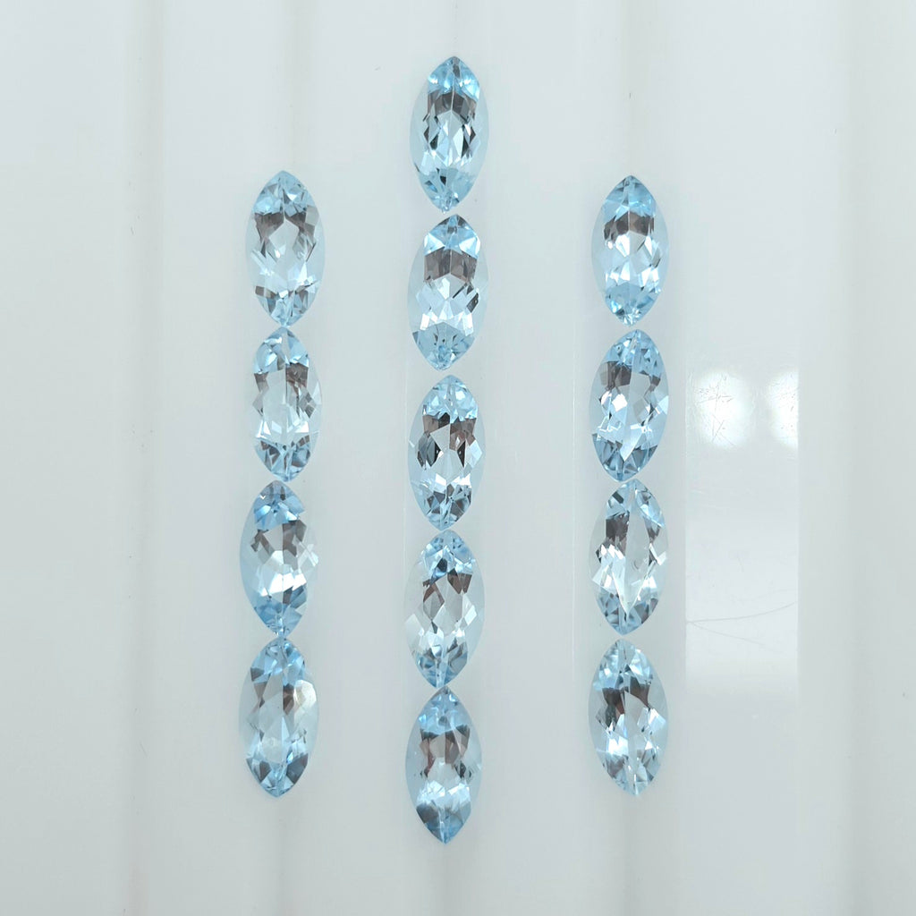 Three vertical rows of faceted marquise-cut light blue gemstones on a plain white background.