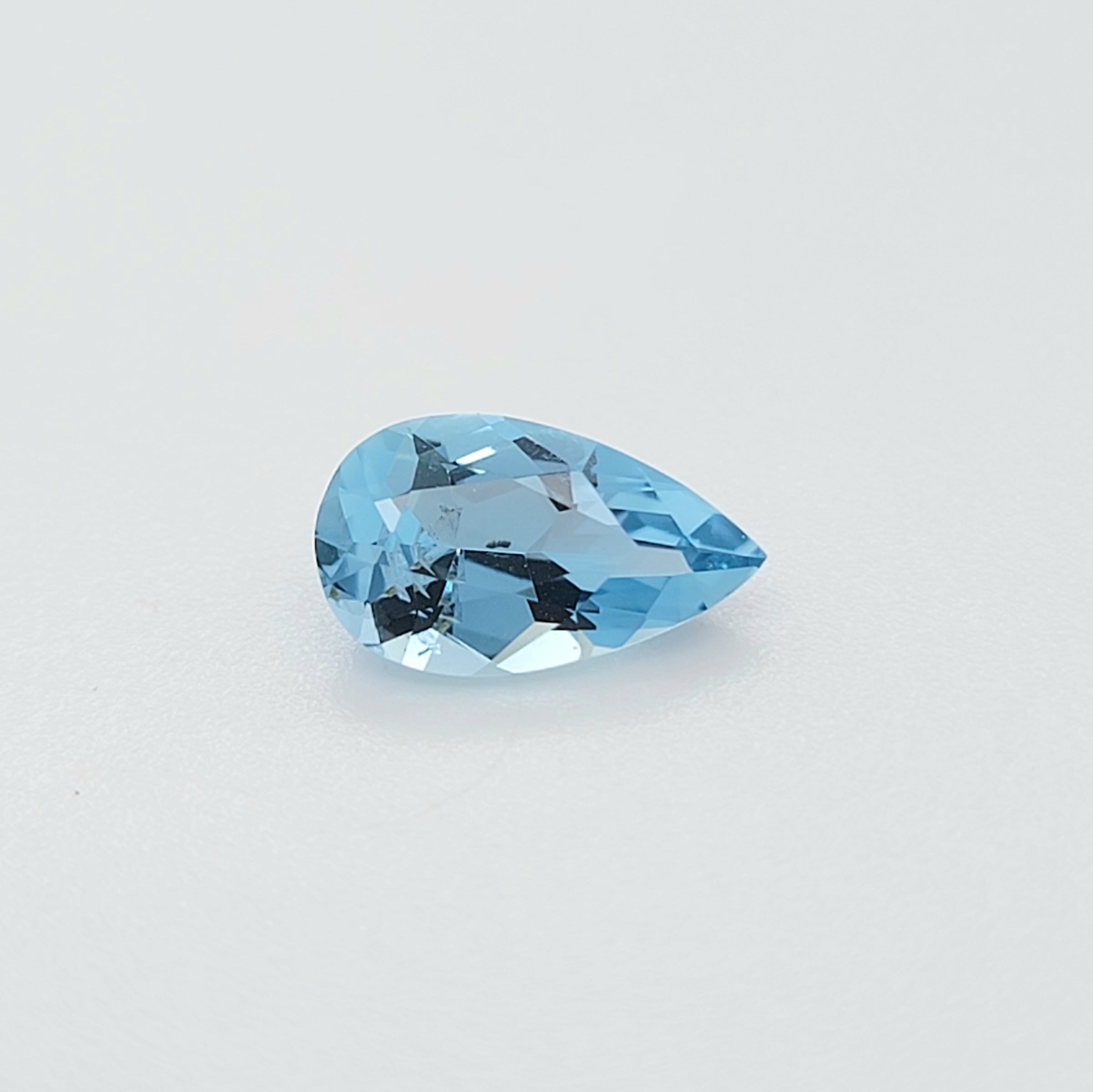A single faceted pear-cut light blue gemstone, displayed on a clean, light gray-white background.