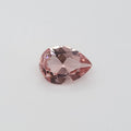 Transparent pink pear shaped gemstone on a white background