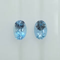Two oval-cut light blue gemstones displayed side by side on a plain light background.