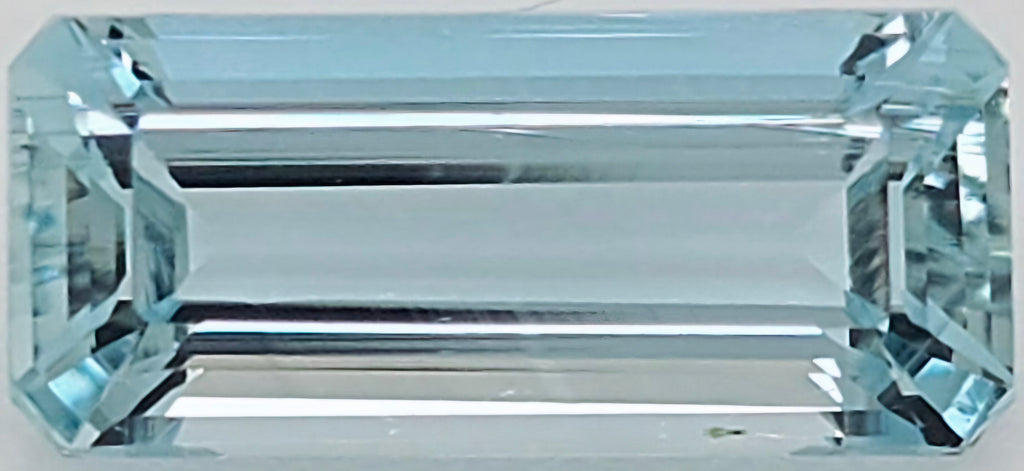 A light blue emerald-cut gemstone with a rectangular shape and beveled corners, shown against a plain white background.