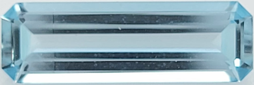 A light blue emerald-cut gemstone, showing clear facets and a transparent structure.