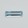 A rectangular emerald-cut light blue gemstone with a faceted, reflective surface, centered on a plain light gray background.