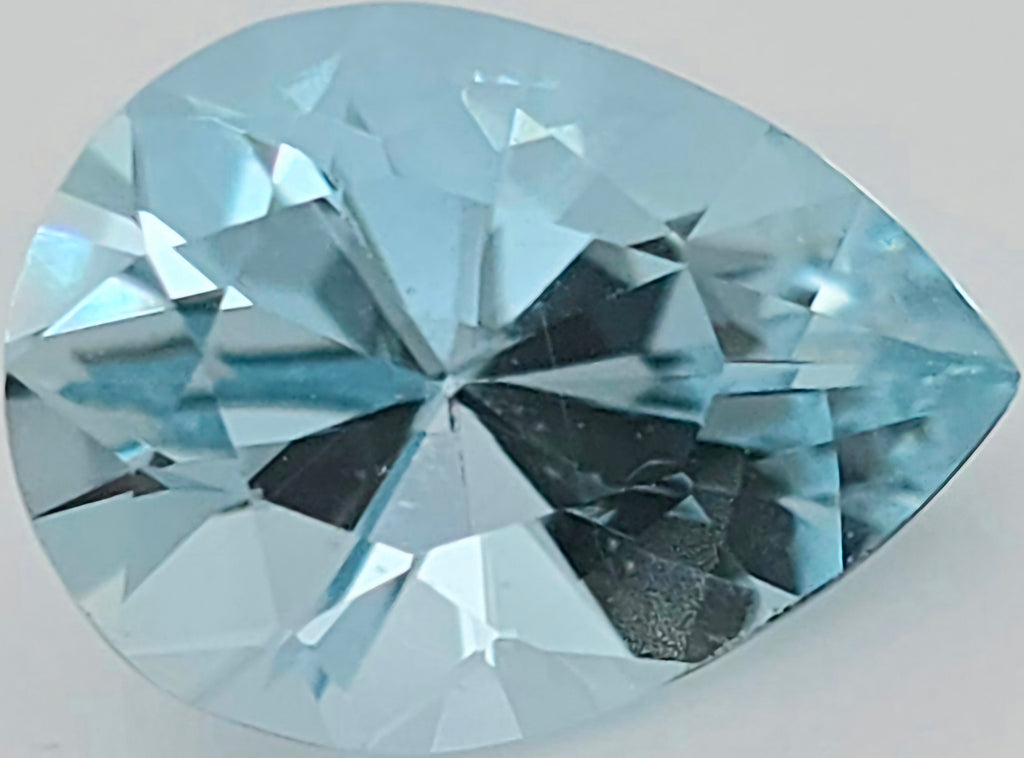 A faceted pear-cut light blue gemstone, shown in close-up on a plain light background.