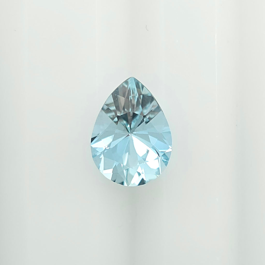 A single faceted teardrop-shaped light blue gemstone centered on a plain white background.