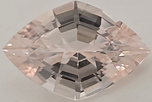 A lozenge cut pink gemstone with a faceted, clear appearance, centered on a light gray background.