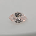 A single lozenge cut pink gemstone with a faceted, reflective surface, centered on a plain light gray background.