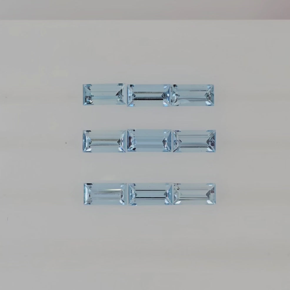 Video of nine rectangular light blue faceted stones arranged into three columns on a plain white background