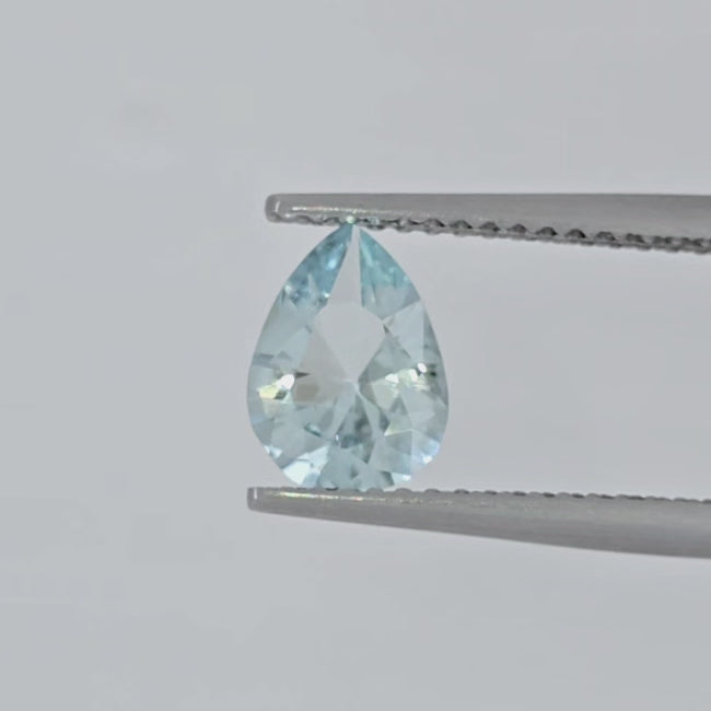 Video of a light blue pear shape faceted stone in tweezers against a plain white background