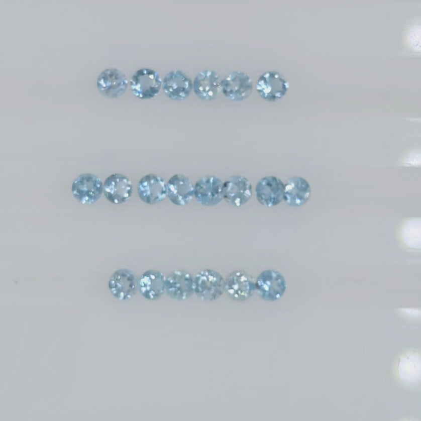 Video of twenty round light blue gemstones arranged in three rows on a plain white background